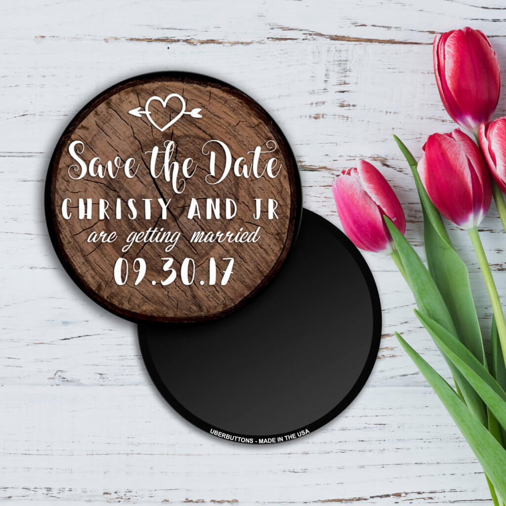 save the date button woodslice design with pink tulips on white wood background
